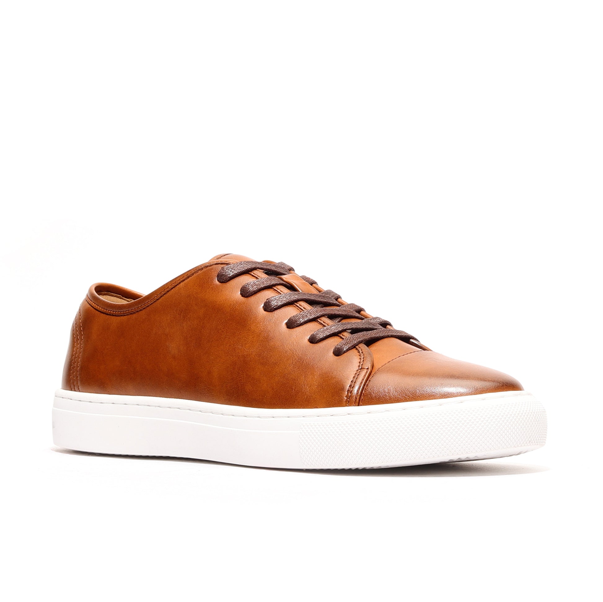 Side profile of cognac full-grain leather sneakers for men featuring cap-toe detail and flexible rubber outsole.