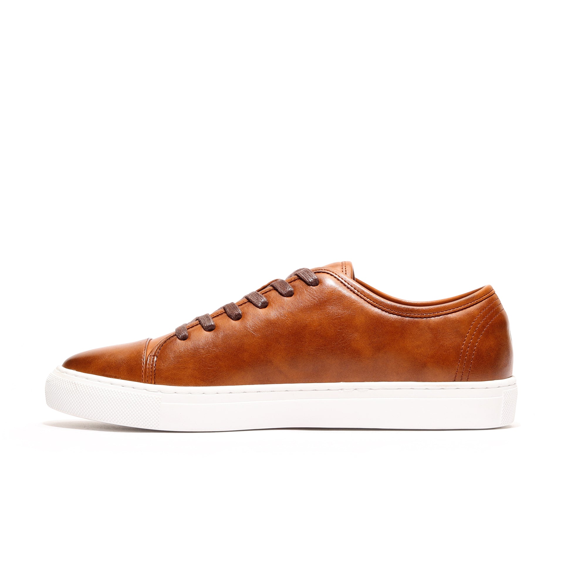Close-up of cognac Oscar Cap-Toe Sneaker, highlighting genuine leather upper and elegant finish.