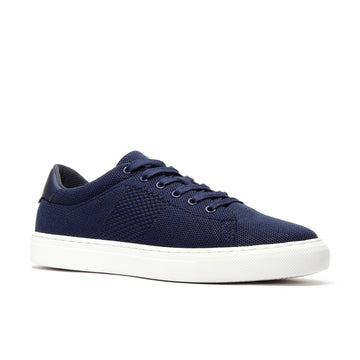 Angled view of navy casual leather sneakers for men with breathable knit upper.